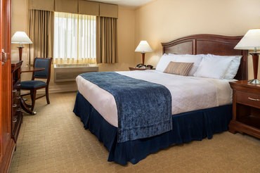 A standard room at The Inn at Turning Stone with a king bed, television, and desk and window