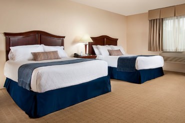 A standard room at The Inn at Turning Stone with two comfortable  king beds next to each other 