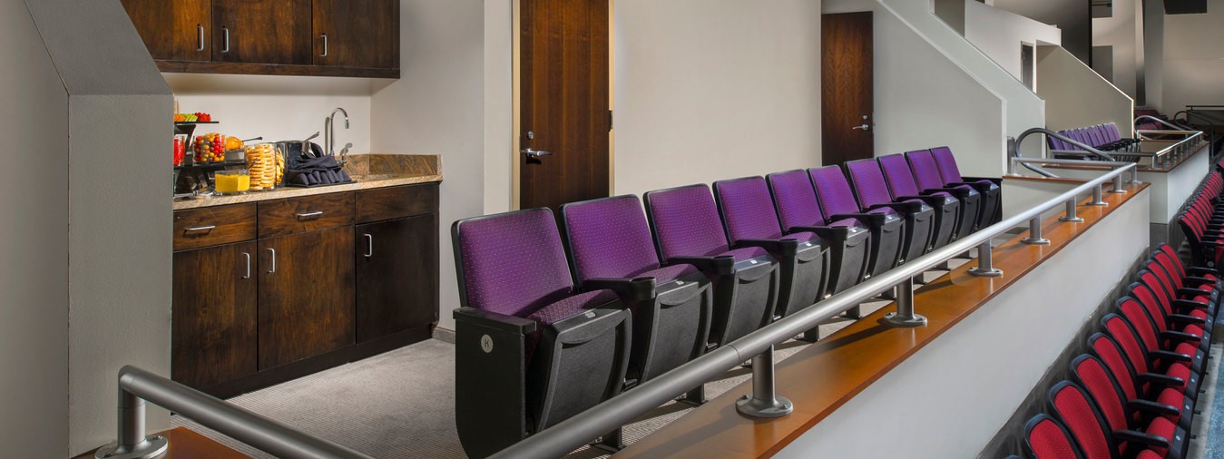 A row of theater-style seats in a private box with a kitchenette in the Event Center at Turning Stone