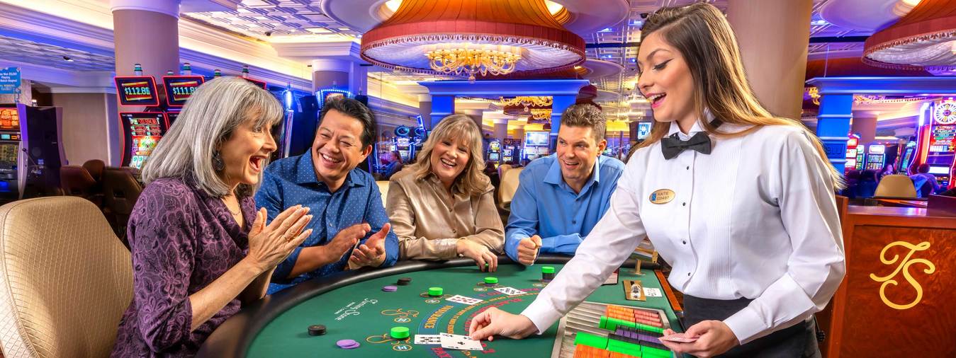 Turning Stone Casino blackjack dealer deals winning hand to woman at blackjack table 