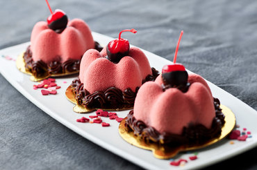 Mousse cake topped with chocolate dipped cherries