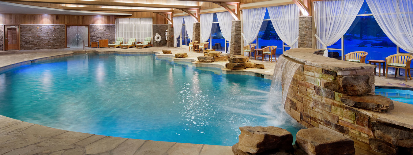 A blue-water indoor pool with a rock waterfall, one of three pools on the Turning Stone Resort Casino property