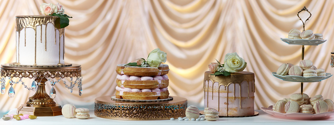 cakes and pastries displayed with gold curtain background