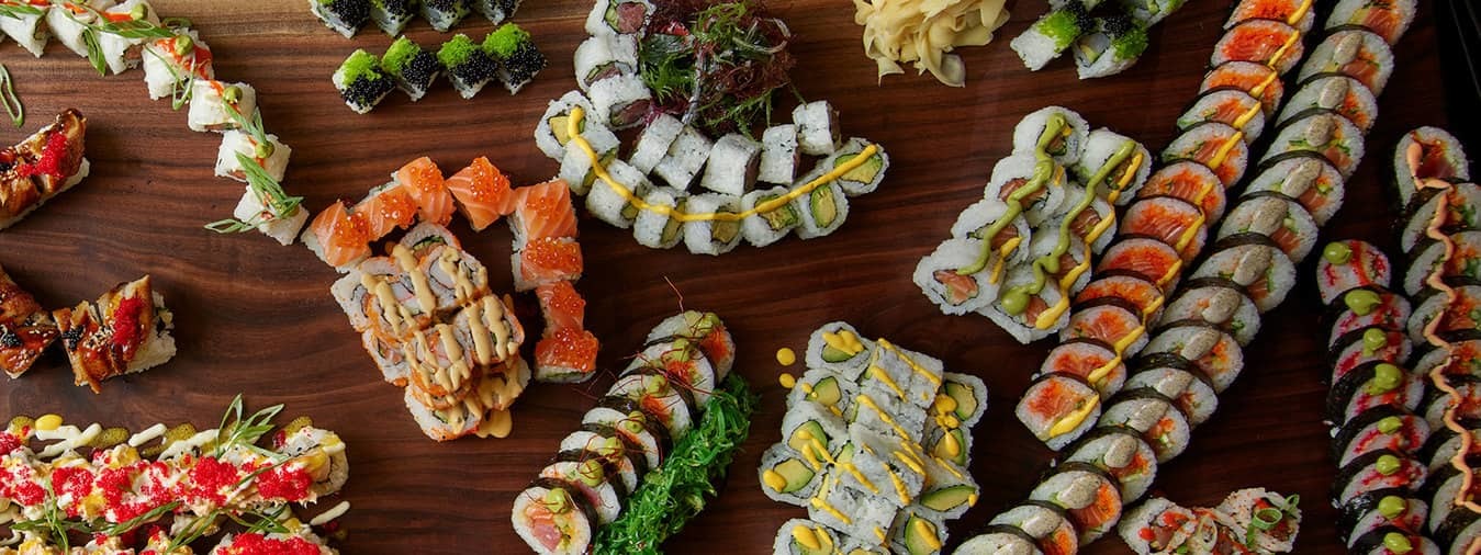 An assortment of sushi rolls line a table