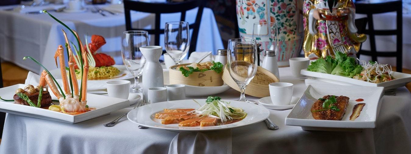 Plated crab legs and fish with empty glasses on a table 