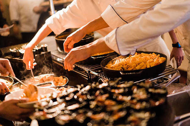 chefs cooking food over stove