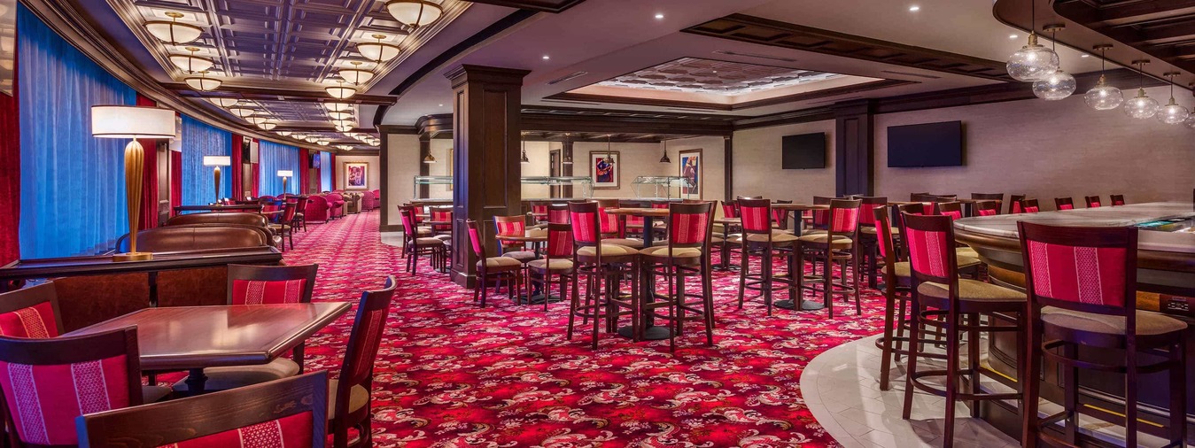 Red backed bar chairs line the bar in the VIP Parlor 