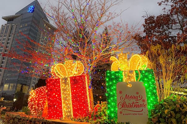 two large christmas presents covered in lights with turning stone in the distance