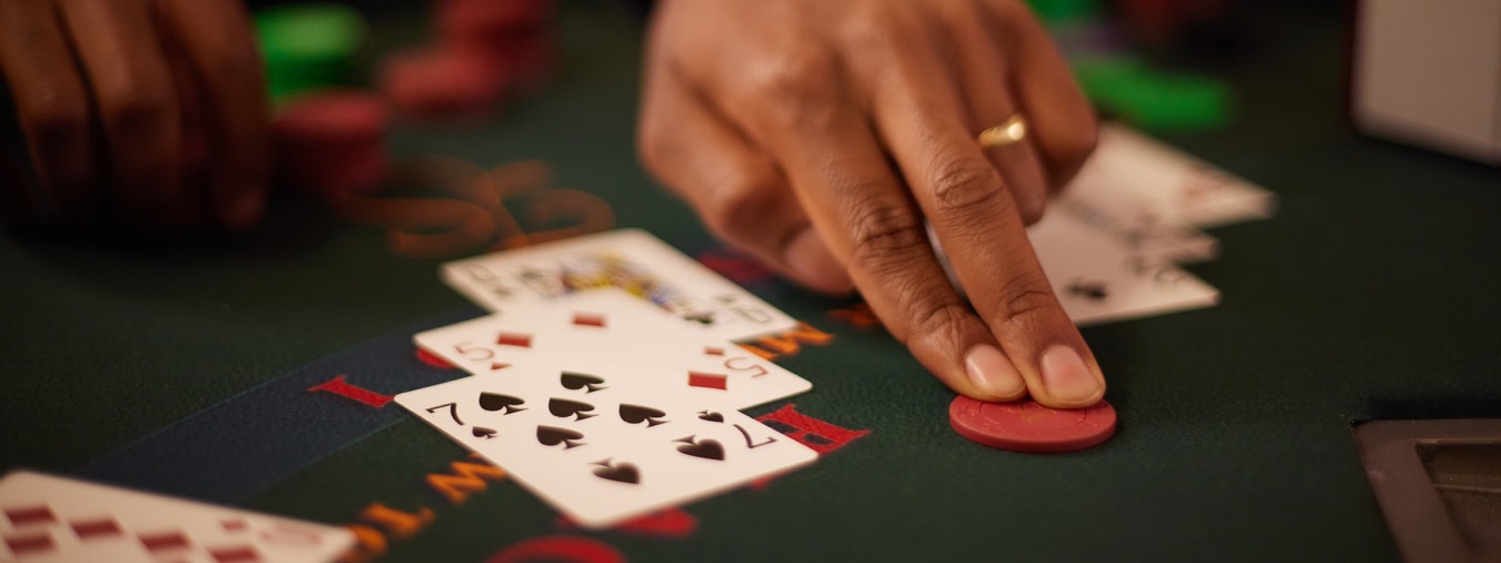 Turning Stone Casino blackjack dealer deals winning hand to woman at blackjack table 