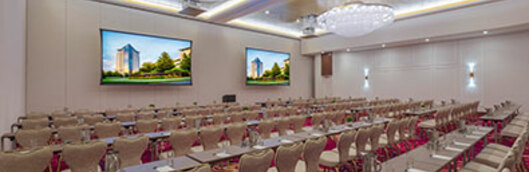 Large corporate conference center with projector screens, and seating