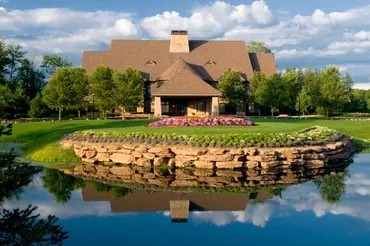 Front view of the clubhouse with a pond and beautiful garden in the foreground 