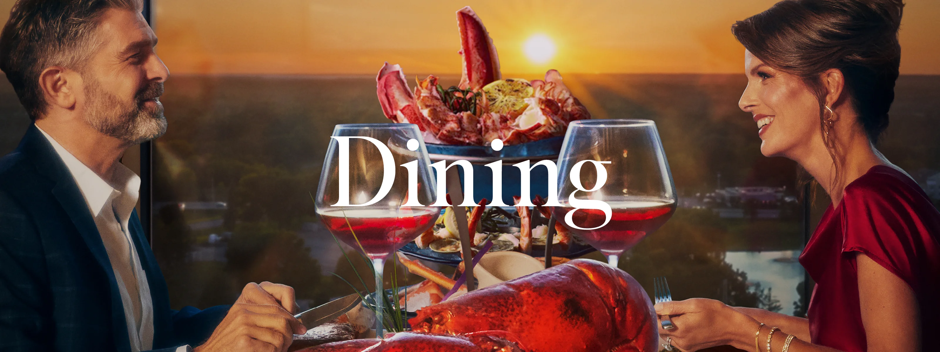 A guy and woman having drinks and lobster in the sunset
