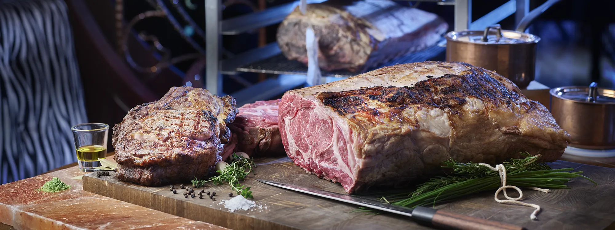 Sliced steak with seasoning and glass of oil