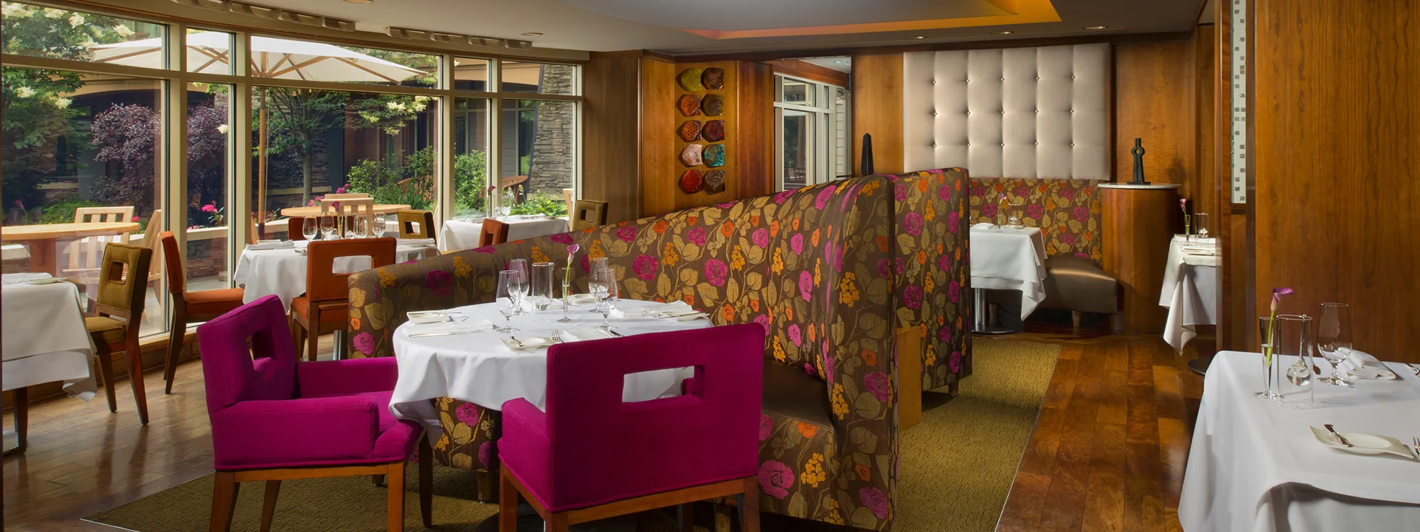 Pink and orange booth seating with a table and pink chairs