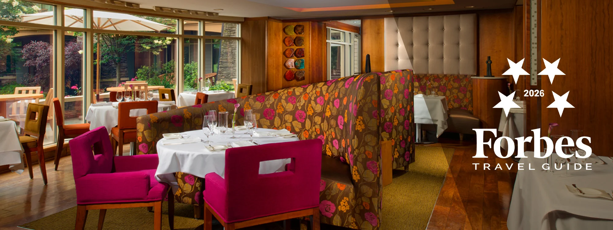 Pink and orange booth seating with a table and pink chairs