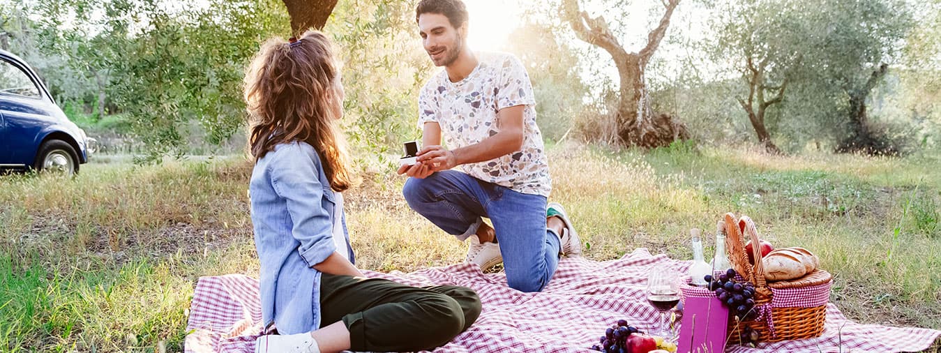 man proposing to woman on a picnic