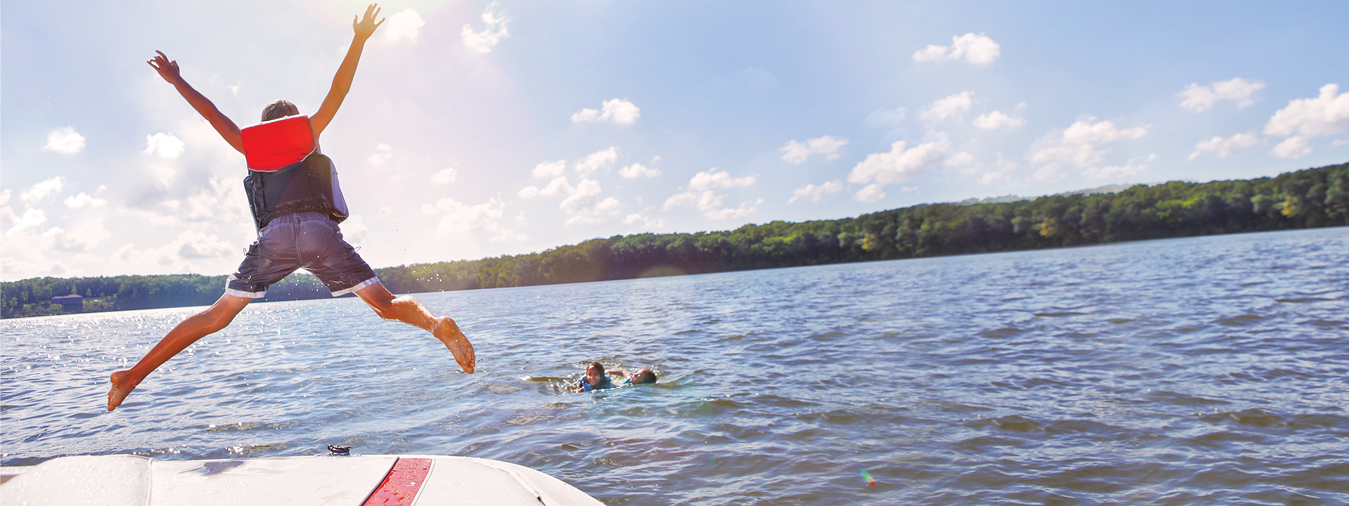 child jumping off boat into lake