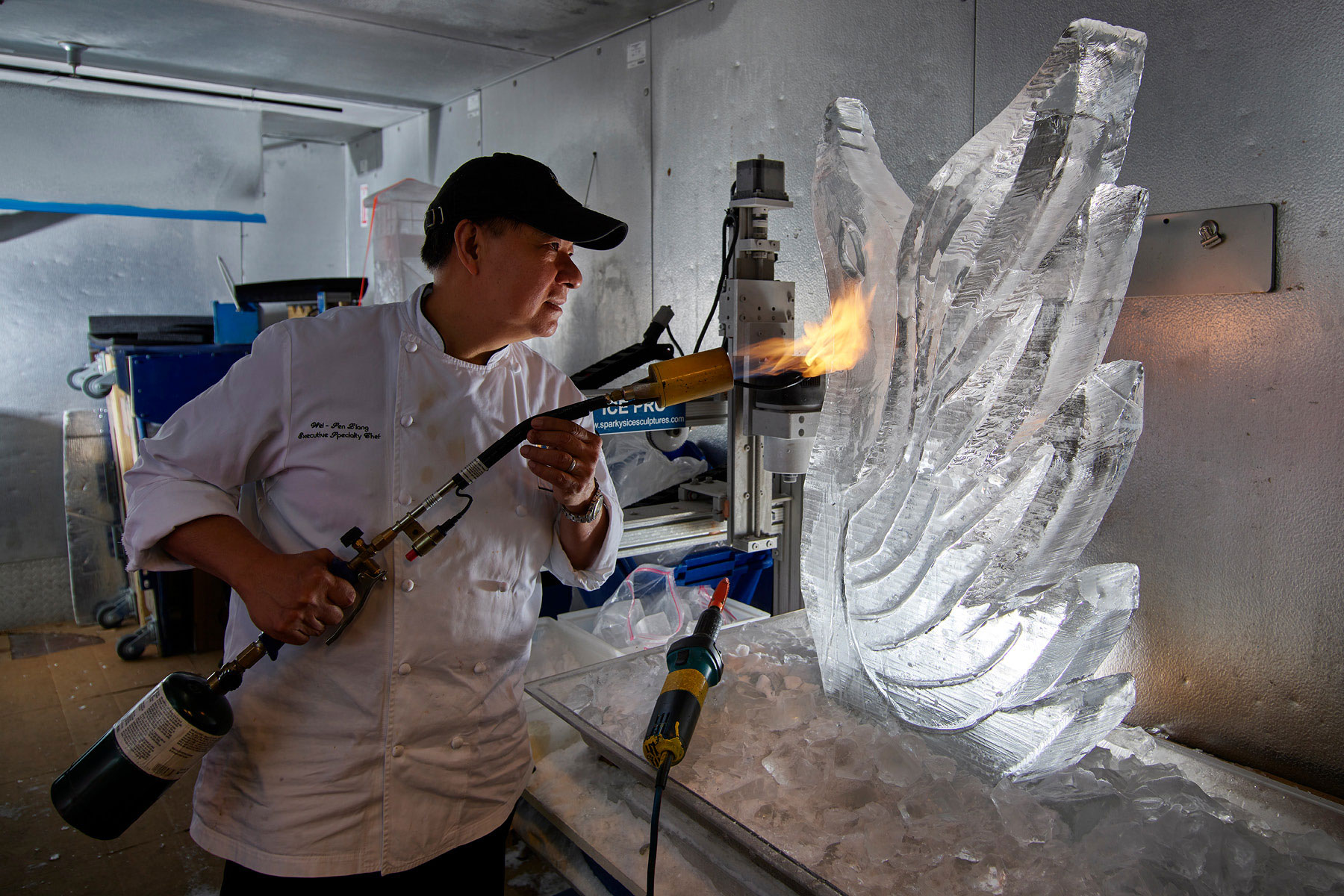 Ice sculptor using a torch to prepare a decorative piece for a wedding reception