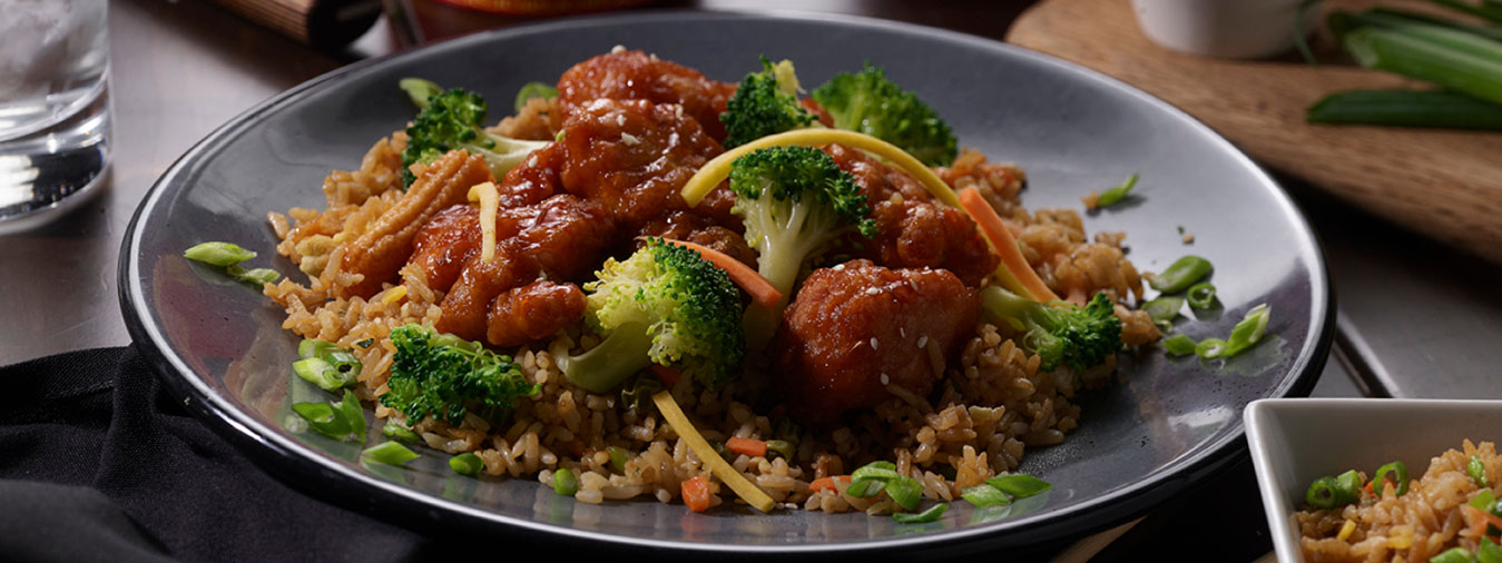 Sesame chicken with prok fried rice and fresh steamed broccoli plated at Seven Kitchens buffet