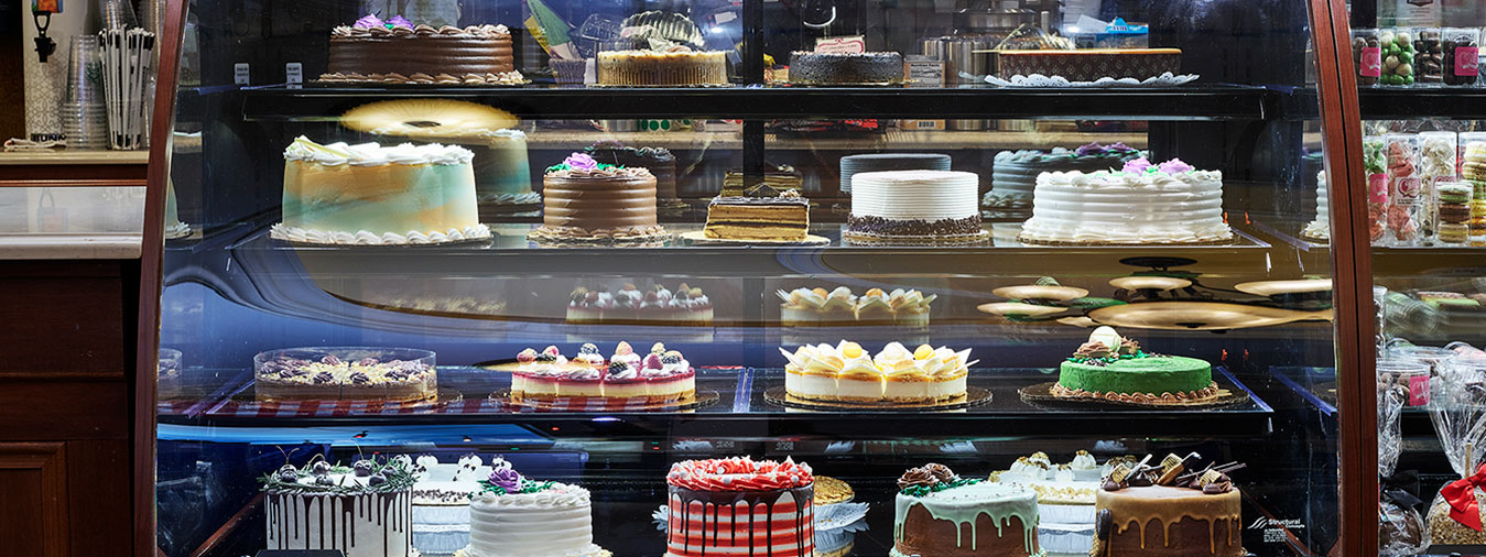 Bakery cakes in a glass display case at Opals Bakery