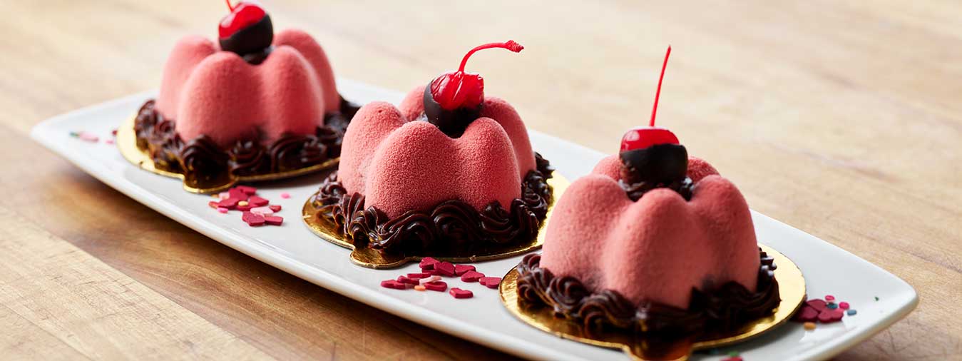 Mousse cake topped with chocolate dipped cherries