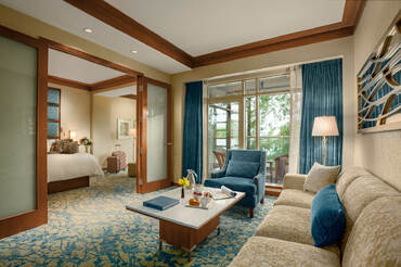 A single king bed in the deluxe suite at The Lodge with a fire in the fireplace