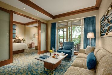 image of redesigned suite at the lodge at turning stone with blue accent colors on carpet, chair, curtain and more